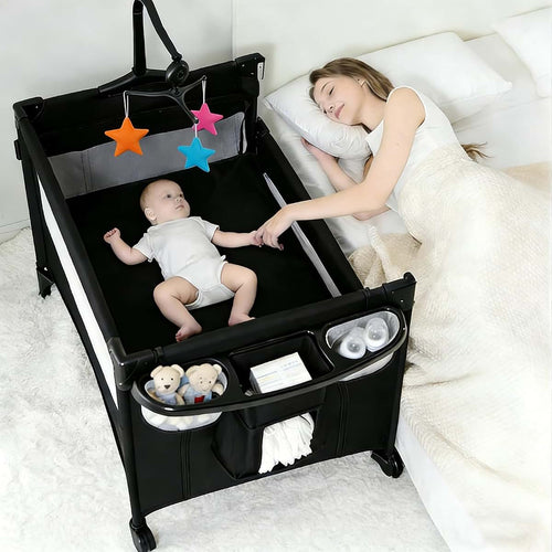 Suttonbebe Pack and Play Baby Bedside Crib, Foldable Travel Crib with Wheels and Storage Basket